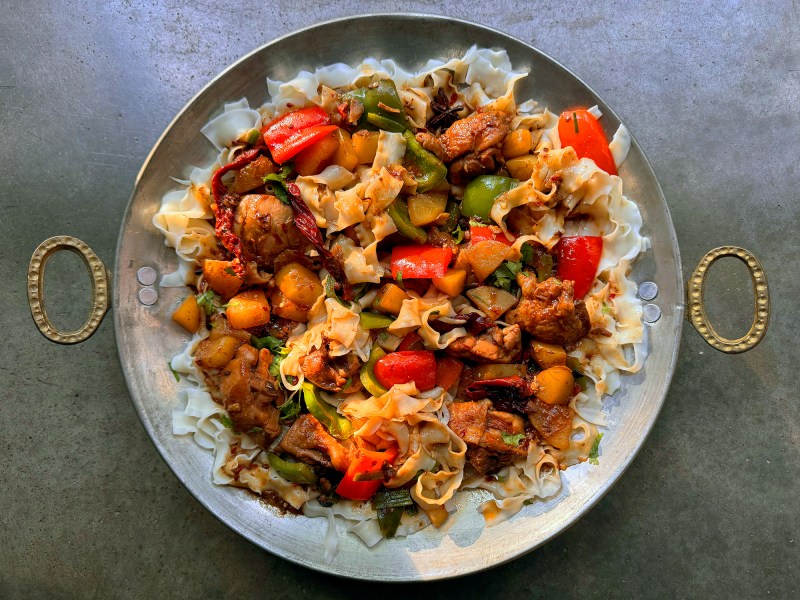 Hand-pulled belt noodles served with Da Pan Ji, soaking up the rich spicy sauce