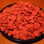Dried goji berries and snacks piled on a plate at a Xinjiang market