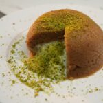Semolina halva dome topped with crushed pistachios, a classic Silk Road sweet