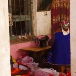 A Uyghur craftswoman sewing traditional embroidered clothing in a Kashgar workshop