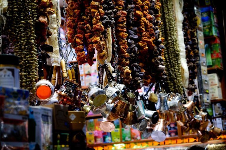 Dried fruit strings and hammered-copper cups at a bazaar stall — classic Xinjiang gifts to bring home
