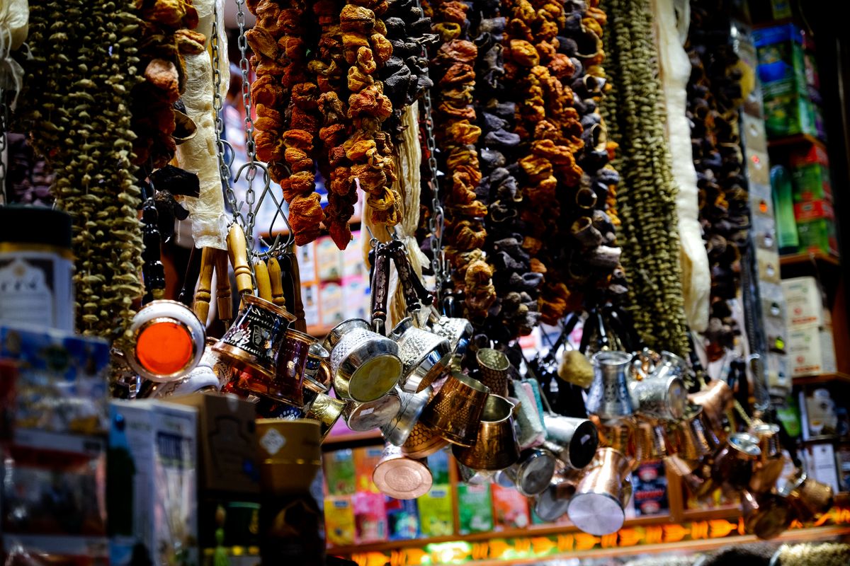 Dried fruit strings and hammered-copper cups at a bazaar stall — classic Xinjiang gifts to bring home