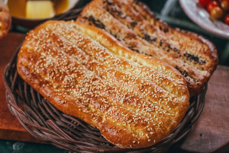 Sesame-topped Xinjiang nan flatbreads stacked in a basket