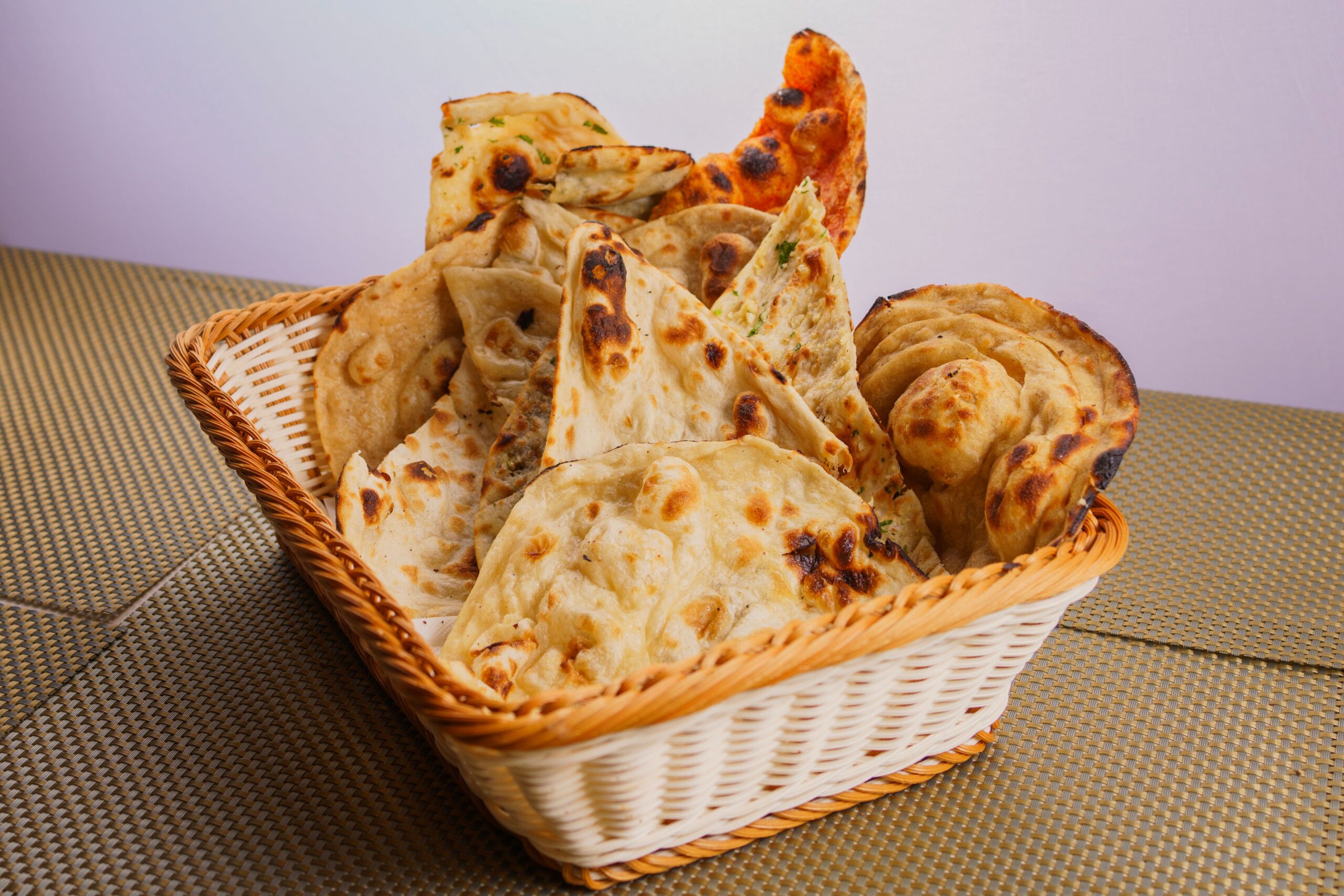 Assorted freshly baked flatbreads in a wicker basket